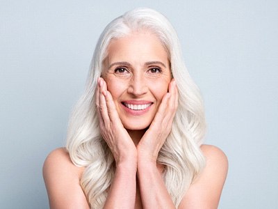 A pretty gray-haired lady enjoying her dental implants
