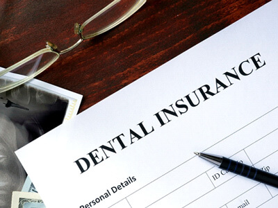 a dental insurance form on a brown wooden table