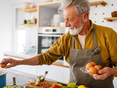 An older, retired man cooking healthy foods