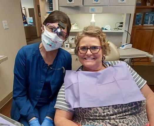 Dental team member with happy dental patient