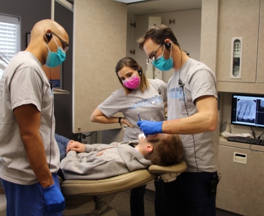 Dental team members treating dental patient with sedation dentistry