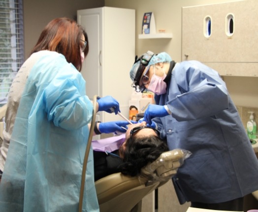 Dentist and dentistry team member treating dental patient