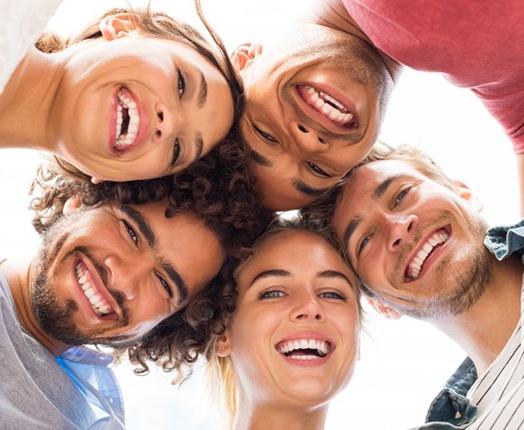 Group of friends huddled in a circle and smiling