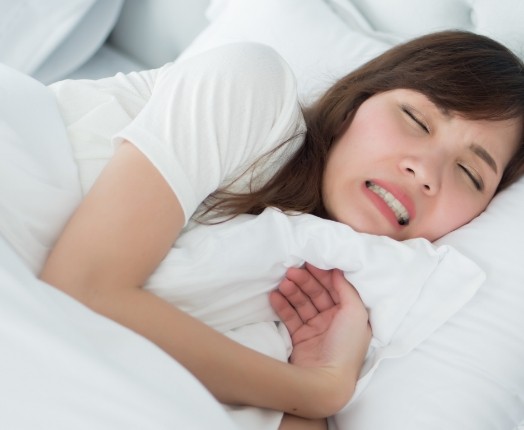 Sleeping woman clenching and grinding teeth