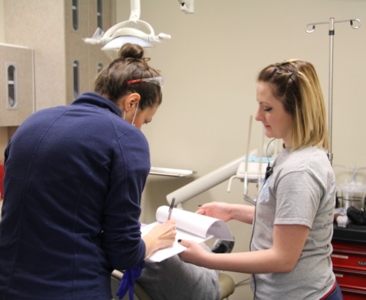 Two dental team members treating dental patient