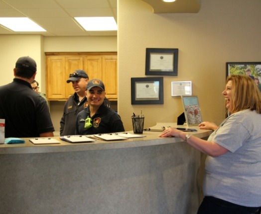 Dental team members behind the reception desk at community event