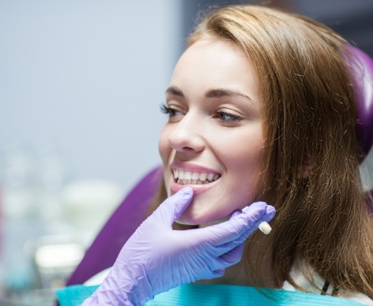 Dentist examining smile after dental crown restoration