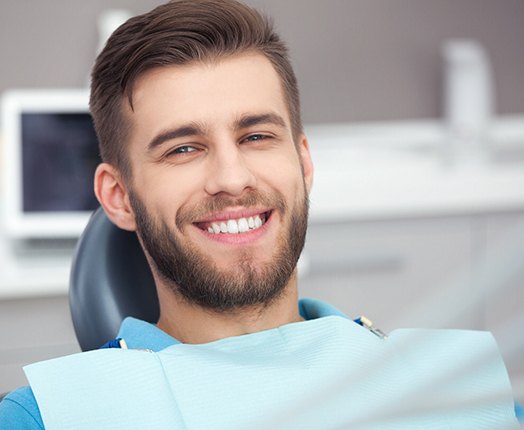 A happy, smiling man sitting in a dentist’s chair