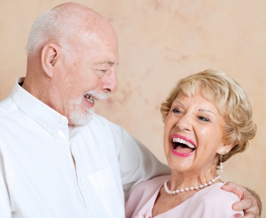 Man and woman with dentures laughing together