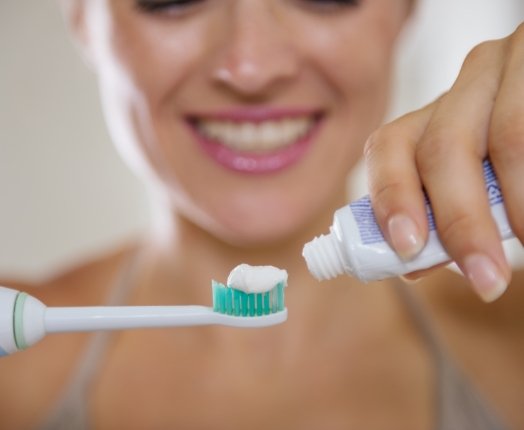 Woman brushing teeth to prevent dental emergencies