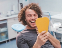 Man looking at smile during preventive dentistry visit