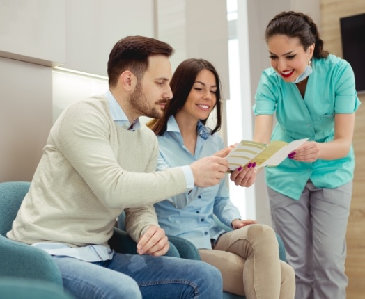 Dental team member showing dentistry patients dental insurance coverage information