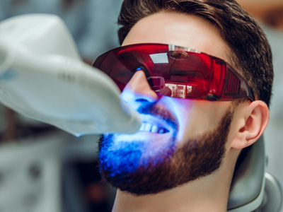 A man receiving an in-office teeth whitening treatment