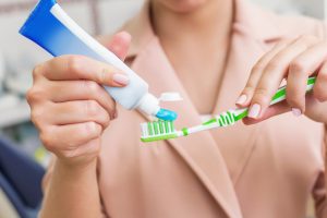 putting toothpaste on a toothbrush