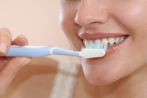 attractive woman brushing her teeth