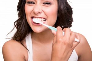 attractive woman smiling brushing teeth