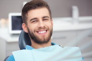 man sitting in dentist chair smiling