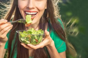 woman eating healthy to avoid visiting emergency dentist in Temple