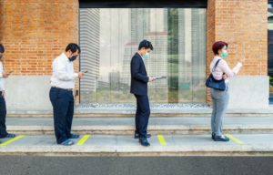 People in line practicing social distancing as recommended by Temple dentist