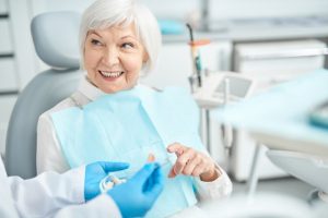 older woman learning about dental implants in Temple