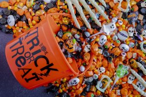 Halloween candy spilling out of orange trick or treat bucket 