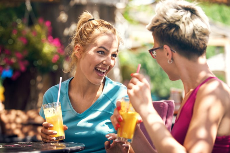 two friends following diet trends by drinking fresh juice 