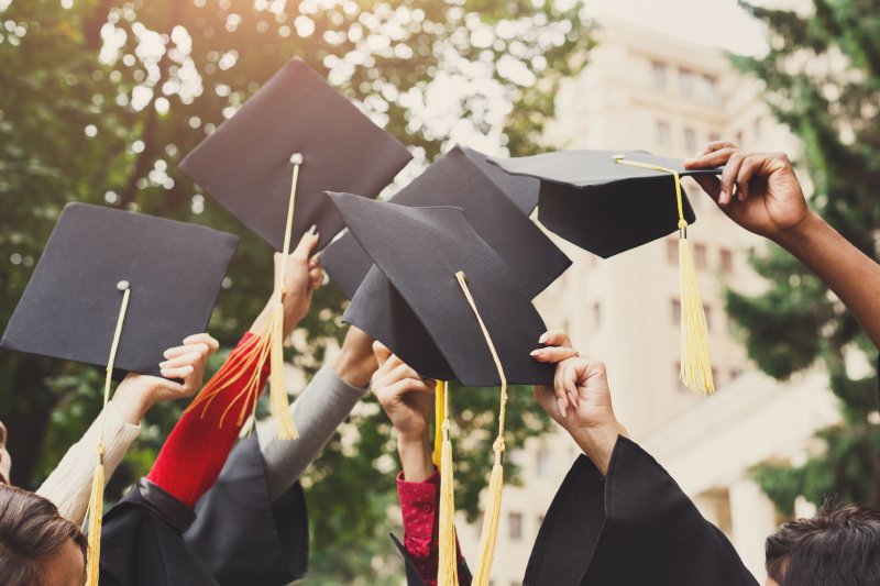 Graduating students raising their caps