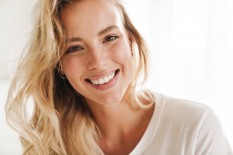 A closeup of a young blonde woman with a beautiful smile