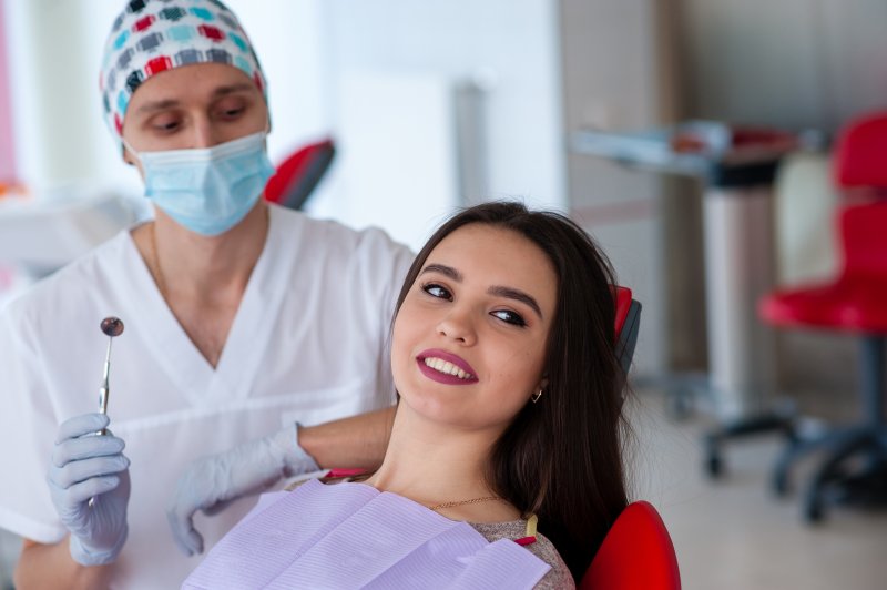 A cosmetic dentist working on a woman’s smile