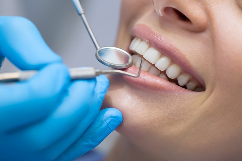 A dentist closely examining a patient’s smile