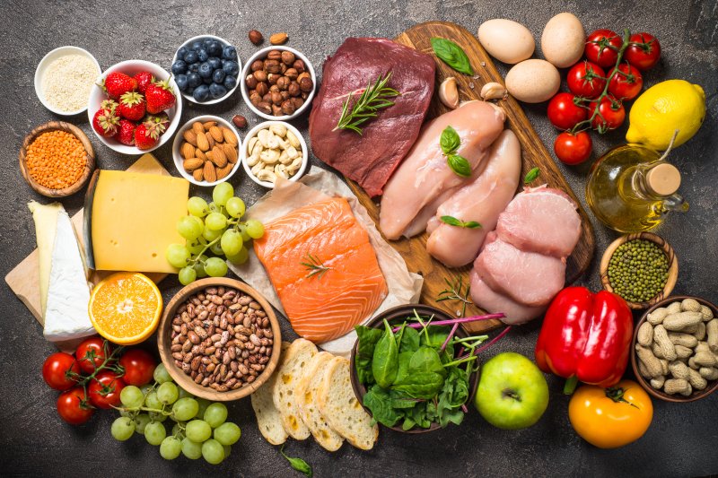 An assortment of healthy foods set against a dark gray background